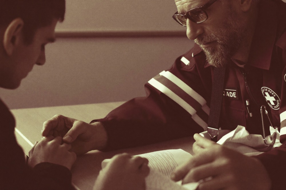 An experienced first responder mentoring a young recruit